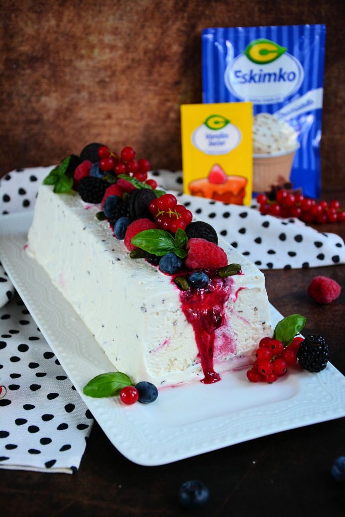 Stracciatella semifreddo sa voćnim prelivom i svežim malinama serviran na letnjem tanjiru